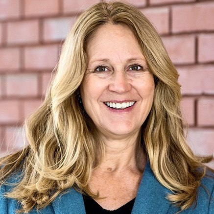 portrait of Sherri Miles standing in front of brick wall