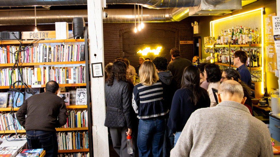 A large crowd overflowing out into the Riffraff bookstore.